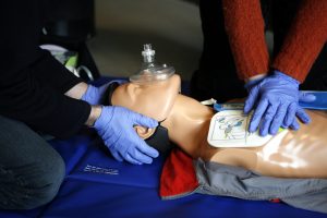 a CPR training dummy and students practicing
