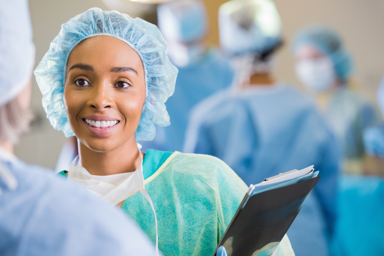 A certified nurse aide consulting with a surgeon in the operating room.